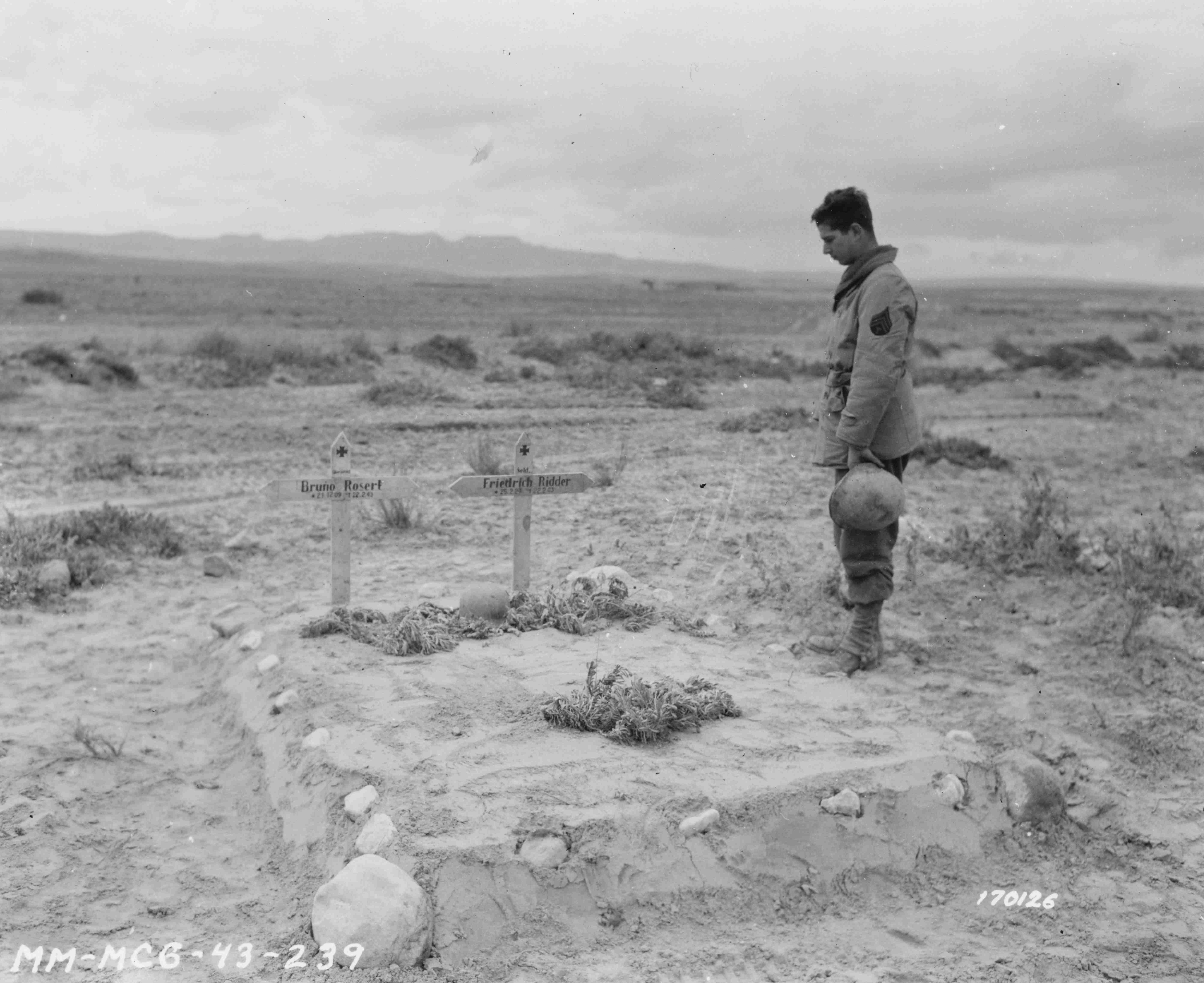 U.S. Army Sgt. T. B. Haber stands by the graves of two German soldiers killed during the Battle of Kasserine Pass in Tunisia. 26 February 1943 [5620 × 4590]